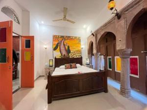 a bedroom with a bed with a painting on the wall at Karma Homestay A Heritage Home in Jodhpur