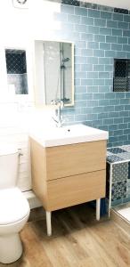 a bathroom with a sink and a toilet and blue tiles at Les 3 mômes in Pontorson +77 photos