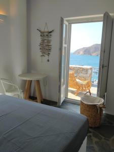 a bedroom with a bed and a view of the ocean at Amorgos Elegant Houses, 6 Villas in Amorgos