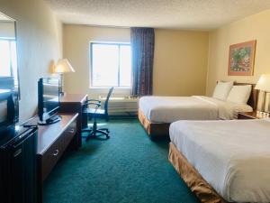 a hotel room with two beds and a television at Norwood Inn Statefare Grounds in Indianapolis