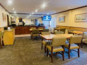 a restaurant with tables and chairs and a kitchen at Norwood Inn Statefare Grounds in Indianapolis