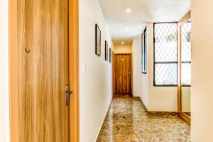 a hallway with a door and a window at FabHotel V Suites Bangalore East Railway Station in Bangalore