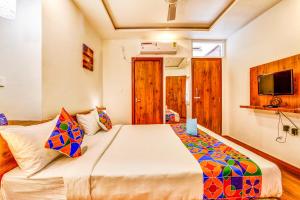 a bedroom with a large bed in a room at FabHotel V Suites Bangalore East Railway Station in Bangalore
