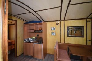 a room with a table and a kitchen in a train at terrebio bungalow in Visnadello