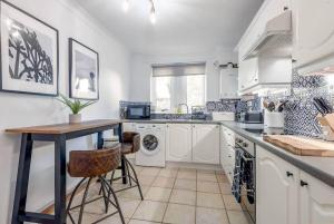 a kitchen with a table and a washing machine at Abbey Villa - Stylish House - Central with Parking in St Andrews