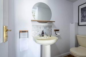 a white bathroom with a sink and a toilet at Abbey Villa - Stylish House - Central with Parking in St Andrews