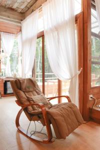 a rocking chair in a room with a window at Woo Ma Ca Moo in Chiang Mai