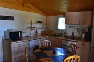 a kitchen with a table and a table and chairs at Chalet grand confort in Beynat