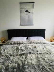 een slaapkamer met een bed met een zwart hoofdeinde bij Ferienwohnung PIER 1 in Cuxhaven in Cuxhaven