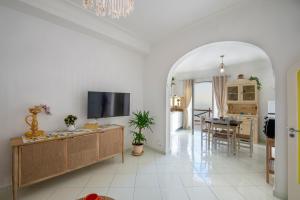a living room with a television and a dining room at Aria di Mare, garden and Sea View in Positano in Positano