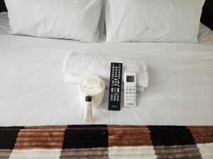 a remote control and a scale on a bed at DBright Lodge in Pretoria +36 photos