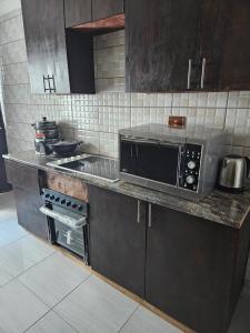 uma cozinha com um micro-ondas e um fogão em DBright Lodge em Pretoria