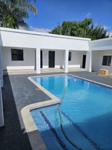 una piscina frente a un edificio blanco en DBright Lodge en Pretoria