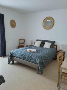 a bedroom with a bed with a blue comforter at Auberge de la vallée de la douve in L'Etang-Bertrand