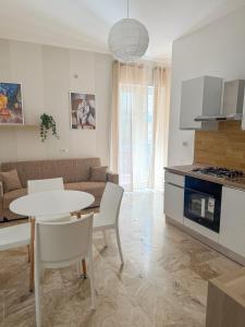 a kitchen and living room with a table and a couch at Living Room Orlando in Corigliano Calabro