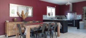 a kitchen with a wooden table and a dining room at Villa piscine proche plages in Angresse