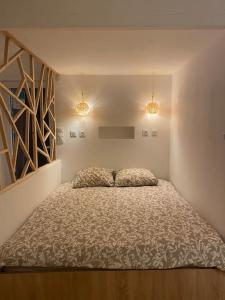 um quarto com uma cama num quarto com duas luzes em Entre terre & mer em Bénesse-Maremne