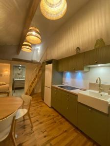 una cucina con tavolo, lavandino e tavolo e una sala da pranzo di Entre terre & mer a Bénesse-Maremne