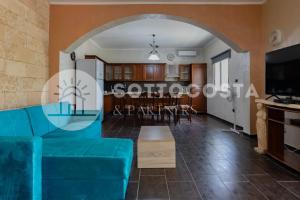 uma sala de estar com um sofá azul e um arco em Blue Horizon - Residence with Pool em Porto Cesareo