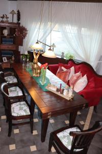 Hotel Kropper Busch Garni في Kropp: طاولة غرفة طعام مع أريكة حمراء وأريكة حمراء