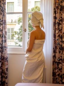 a woman in a wedding dress looking out of a window at MUSES LUXURY SUITES in Corfu