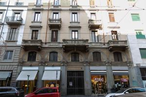 sweet house deluxe في ميلانو: مبنى فيه سيارة حمراء متوقفة أمامه
