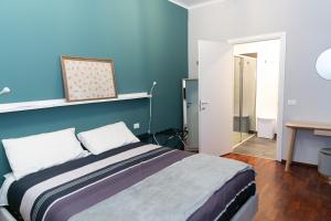 sweet house deluxe في ميلانو: غرفة نوم بسرير مع جدار ازرق