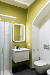 ein Badezimmer mit einem Waschbecken, einem WC und einem Spiegel in der Unterkunft sweet house deluxe in Mailand