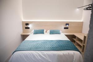 a bedroom with a large bed with blue pillows at Ponteloft - Recuncho in Pontevedra