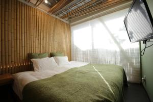 Un dormitorio con una cama grande con ventana. en 葡萄の長屋, en Tokio