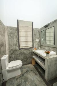 a bathroom with a toilet and a sink and a mirror at The Horizon Hill Top Villa in Unawatuna
