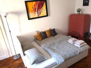 a white couch in a room with a painting on the wall at Cosy condo in the heart of the Upper town Zagreb in Zagreb