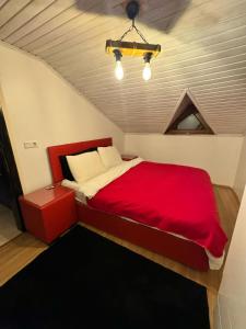 een slaapkamer met een rood bed op zolder bij SNOW HİLL HOUSE BUTİK APART OTEL in Kartepe