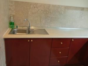 a kitchen with a sink and red cabinets at Ayan Service Suite At Times Square in Kuala Lumpur