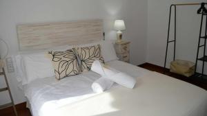 Una cama blanca con dos almohadas encima. en Mahonia Palacio Congresos Parking Concertado en Granada