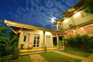 a white house with a porch at night at The Horizon Hill Top Villa in Unawatuna