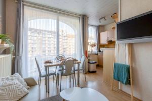 um pequeno apartamento com uma mesa e cadeiras e uma cozinha em Cosy apartment 150m from the beach em Blankenberge