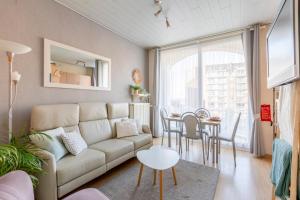 uma sala de estar com um sofá e uma mesa em Cosy apartment 150m from the beach em Blankenberge