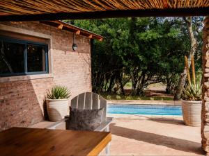 a patio with a chair and a swimming pool at Klipplaatsdrift Safari Lodge in Hofmeyr