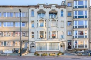 um edifício de apartamentos com uma fachada branca em Cosy apartment 150m from the beach em Blankenberge