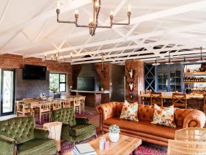 uma sala de estar com sofás e uma sala de jantar em Klipplaatsdrift Safari Lodge em Hofmeyr