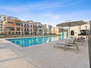una piscina con 2 sillas y una sombrilla en Luxury 4BR Villa with Private Beach and Burj Views en Dubái