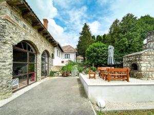 a stone house with a patio with a table and chairs at Ligeti Bástya Vendégház in Liget