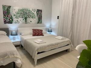 a bedroom with two beds and a painting on the wall at Central Apartments in Crotone