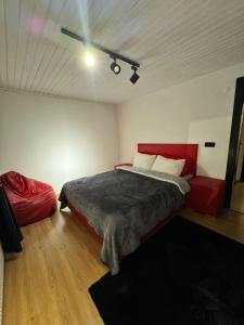 een slaapkamer met een rood bed en een rode bank bij SNOW HİLL HOUSE BUTİK APART OTEL in Kartepe