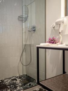 a shower with a glass door next to a sink at MUSES LUXURY SUITES in Corfu +189 photos