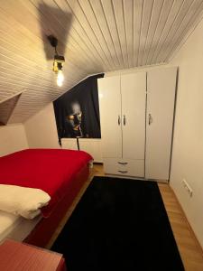 een slaapkamer met een rood bed en witte kasten bij SNOW HİLL HOUSE BUTİK APART OTEL in Kartepe