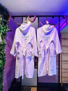two white shirts are hanging on a rack at Jungle Love Loveroom avec Balnéo à 10 min de Disneyland Paris in Serris +20 photos