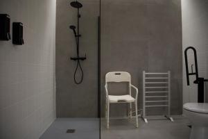 a white chair in a bathroom with a toilet at Ponteloft - Xeitoso in Pontevedra