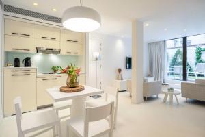 een keuken en een woonkamer met een tafel en stoelen bij B-aparthotel Regent in Brussel